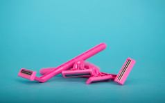 Womens pink generic razors on a blue background