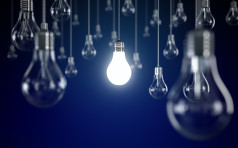 Hanging light bulbs with glowing one isolated on dark blue background